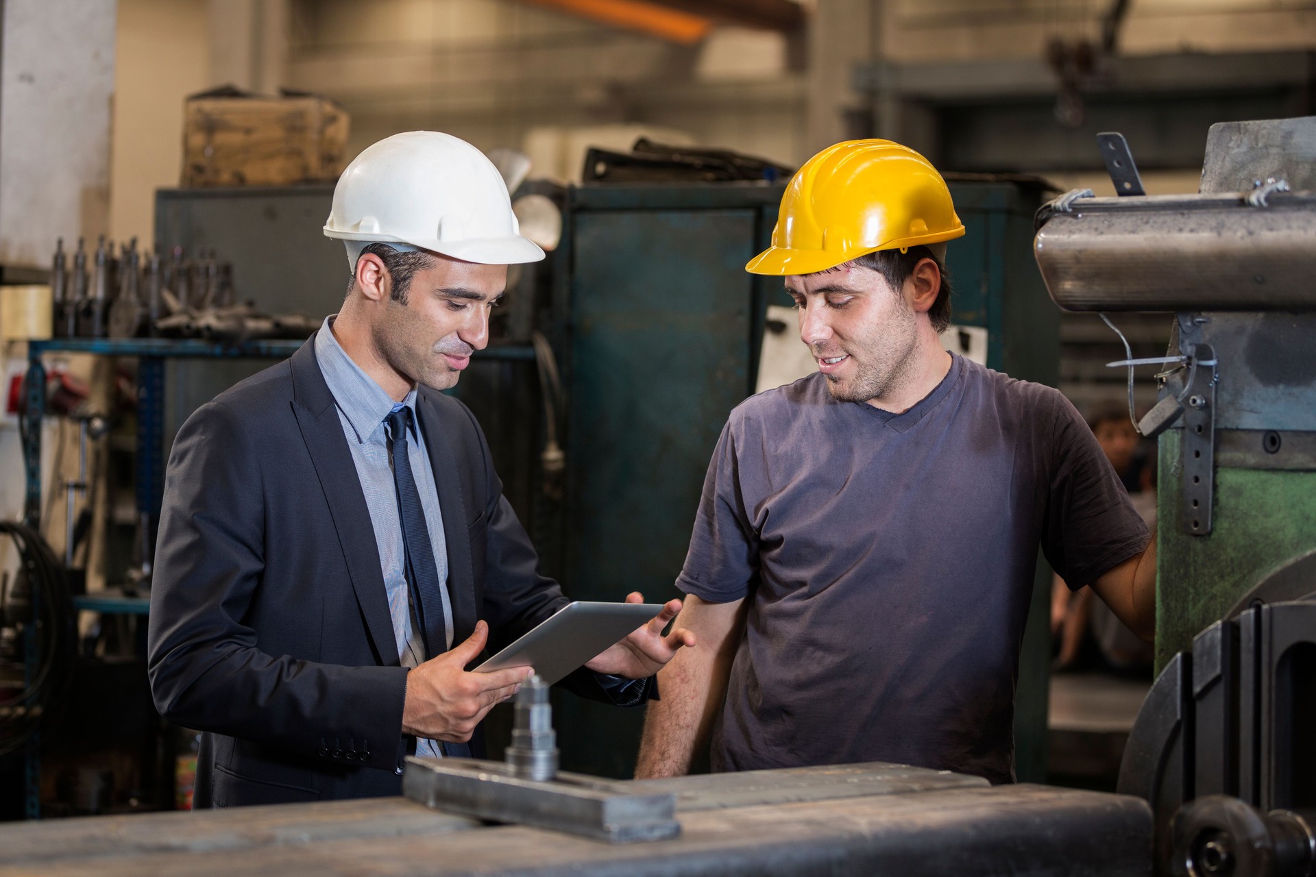 Factory manager talking to an operative in hard hat